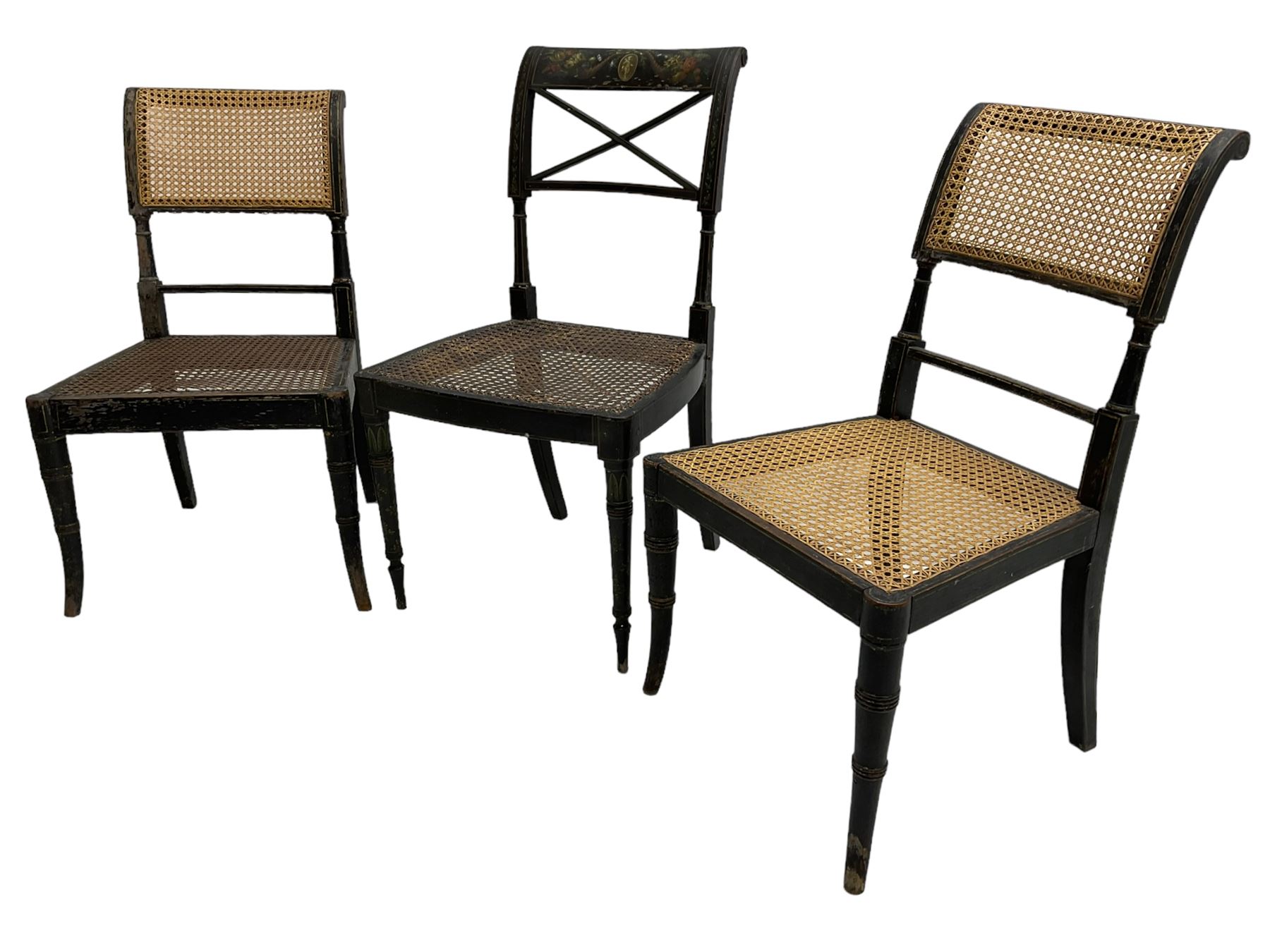 Collection of Regency dining chairs - set of four Regency painted beech dining chairs, with cane seat and back, on collar turned supports with splayed feet (W46cm, H84cm); a pair of Regency ebonised dining chairs (W47cm, H77cm); and a single Regency dining chair, the cresting rail painted with floral cornucopias and central putto vignette, X-frame back over cane seat, on collar turned front supports painted with foliage (W46cm, H84cm) (7)