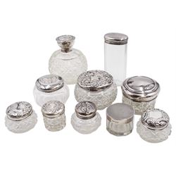 Mid 20th century silver topped cut glass scent bottle, with hobnail and octagonal decoration to the glass body, the silver lid repousse decorated with putti, hallmarked Boots Pure Drug Company, Birmingham 1943, together with nine silver topped glass dressing table jars, with designs including butterfly and romantic scene,  all with hallmarked with various makers and dates