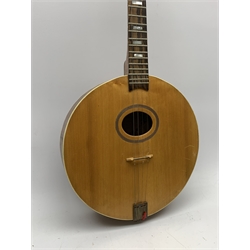 Four-string banjo guitar with mahogany circular back and sides and spruce top, mother-of-pearl inlaid fingerboard and headstock, bears humorous label 'Fender Bedpanjo', L95cm