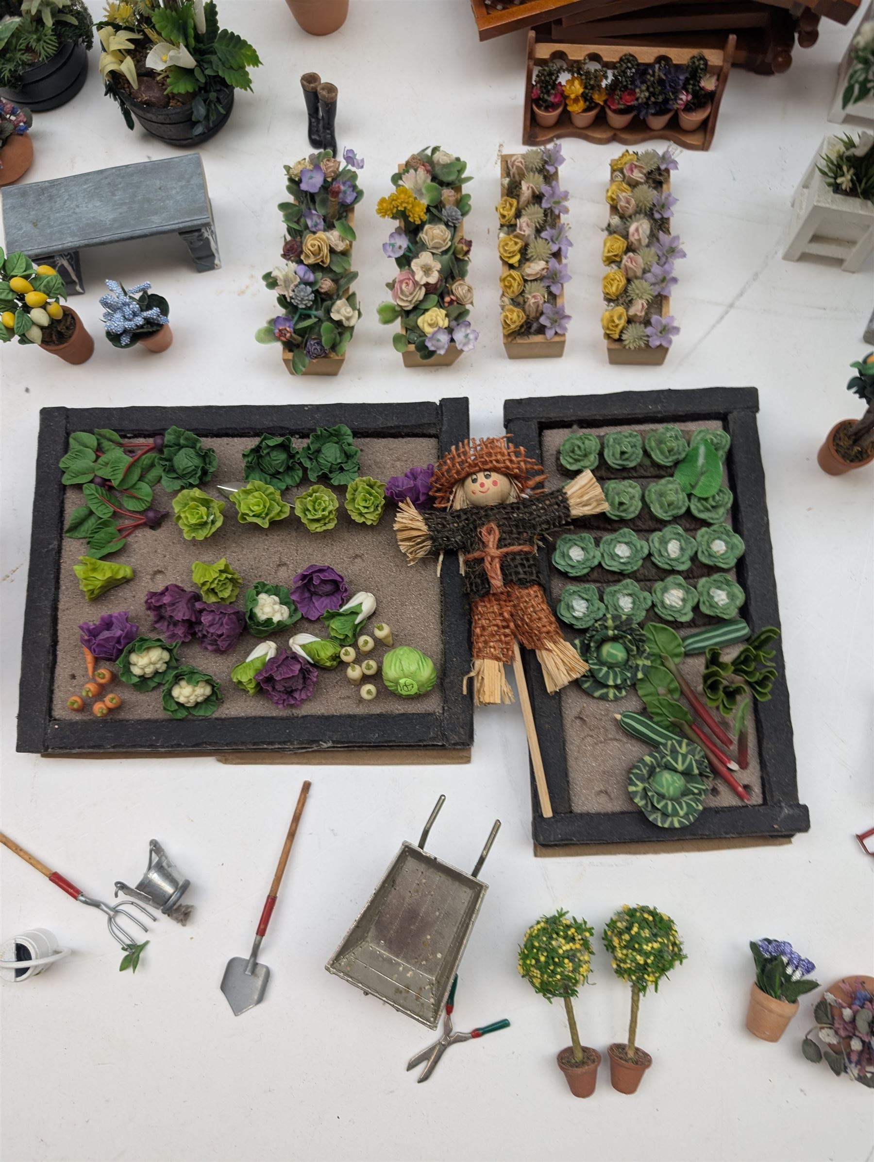 1:12 scale dolls house allotment and garden accessories, including wooden shed on a stone effect base, two vegetable patches, terracotta plant pots with flowers and foliage, stone effect plant pots, other planters, loose sunflowers, scarecrow, rabbit hutch, garden tools, fencing panels, etc 