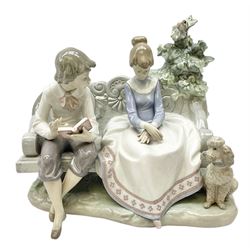 Lladro figure, Poetry of Love, modelled as a boy seated reading from a book next to a girl on garden bench with a dog at her feet, sculpted by Regino Torrijos, with original box, no 5442, year issued 1987, year retired 1998, H22cm