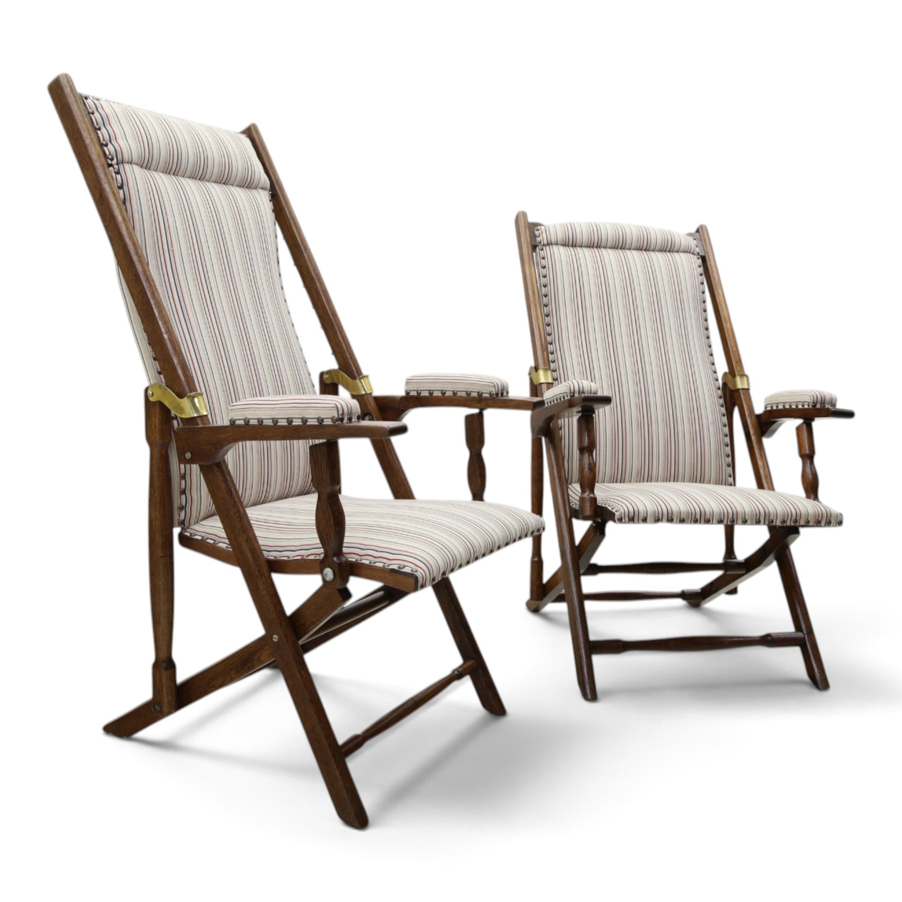 Pair of early 20th century oak framed garden reclining and folding deckchairs, high back and seat upholstered in striped fabric with padded armrests