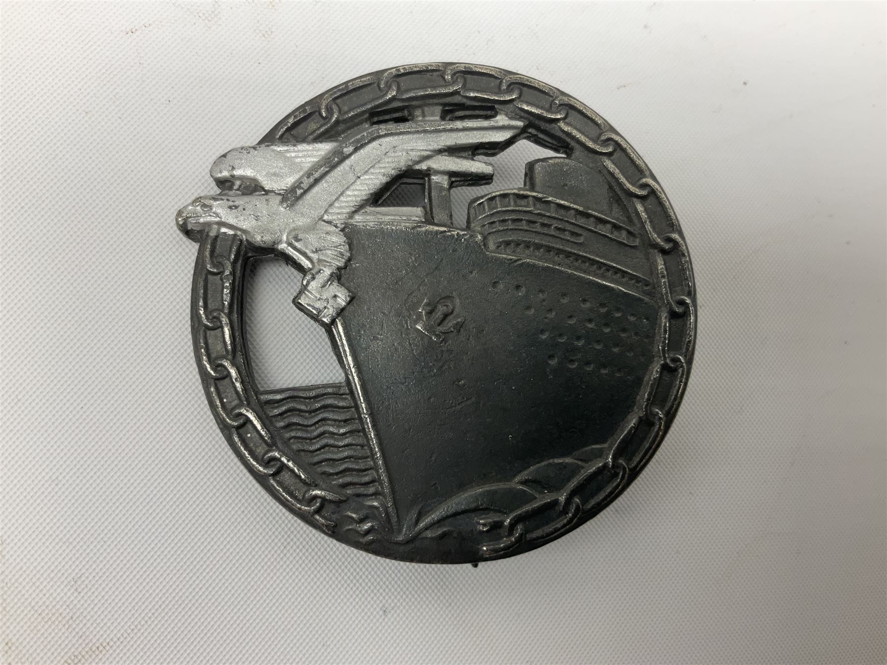 Three WW2 German badges comprising Blockade Runner War Badge and Coastal Artillery badge, both marked 'Fec Otto Placzec Berlin'; and Infantry Assault Badge; all with fixing pins (3)