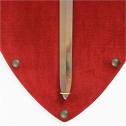 Three replica gauntlets, each housed upon a red wall shield, two with daggers, the third with a sword, largest H102cm