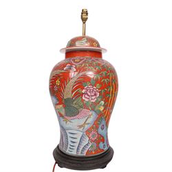 Table lamp of baluster form, decorated with ducks and lilies upon a red ground upon a circular wooden base, H64cm
