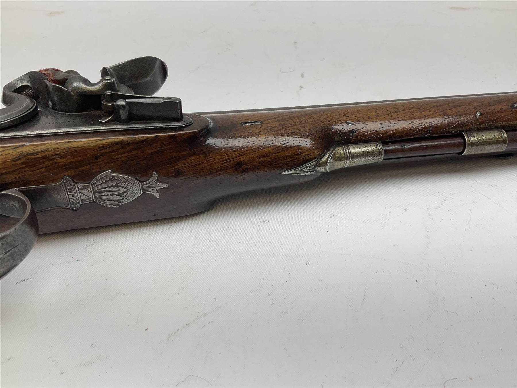 Early 19th century flintlock 16-bore overcoat/duelling pistol by William Bond Lombard Street London, the 23cm octagonal brown stub twist damascus barrel with small foresight, two barrel pins and ram rod under, inscribed Lombard Street London to the top and W. Bond to the action, full walnut stock with lightly engraved steel furniture, pineapple finial and escutcheon, half cock facility L39cm; loose mounted on later mahogany display stand with trade label