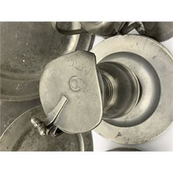 Collection of 18th and 19th century pewter, comprising two chargers, eight large plates, twenty six smaller plates, two bowls, three lidded measures, two jugs, tappit hen, and tankard, the plates with various marks and touch marks, including pseudo 'hallmarks', largest charger 37cm, large plates D30cm, smaller plates D24.5cm, tappit hen H26.5cm