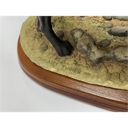 Two Border Fine Arts models, the first example a black Labrador, by Margaret Turner, upon oval wooden base, the second example a Dogs Galore Black Labrador, together with a Sherratt and Simpson model of a black Labrador