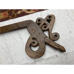 Ikat Man’s Cloth (Hinggi Kombu), East Sumba, Indonesia, woven in red, blue and yellow-brown warp ikat, constructed of two mirroring long panels, the motifs arranged in four bands depicting warrior figures astride rearing horses, high-ranking figures and guardians within geometric borders, on carved wooden wall hanger, L295cm
