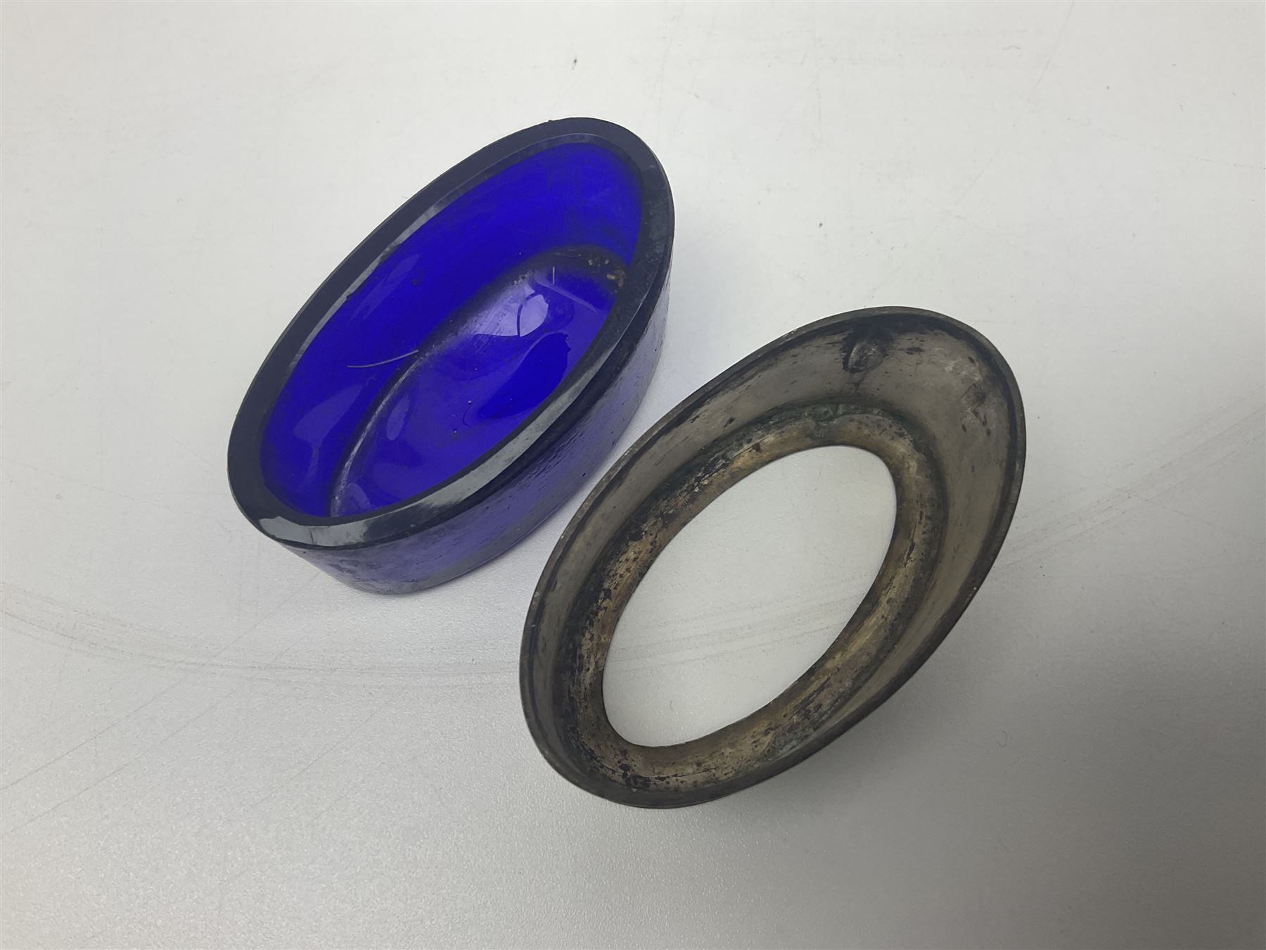 Modern two piece silver cruet set, comprising pepper shaker and open salt, each with shaped rims and upon four pad feet, hallmarked William Suckling Ltd, Birmingham 1962, together with an early 20th century silver open salt, of oval form, hallmarked William Aitken, Birmingham 1918