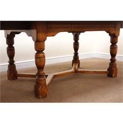  17th century style oak extending dining table with two leaves, curved ends, turned supports joined by an 'X' floor stretcher (W271cm, H75cm, D121cm) retailed by Geoffrey Benson  