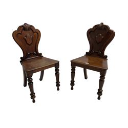 Pair of Victorian mahogany hall chairs, shaped moulded back carved with cartouche, moulded seat on turned front supports