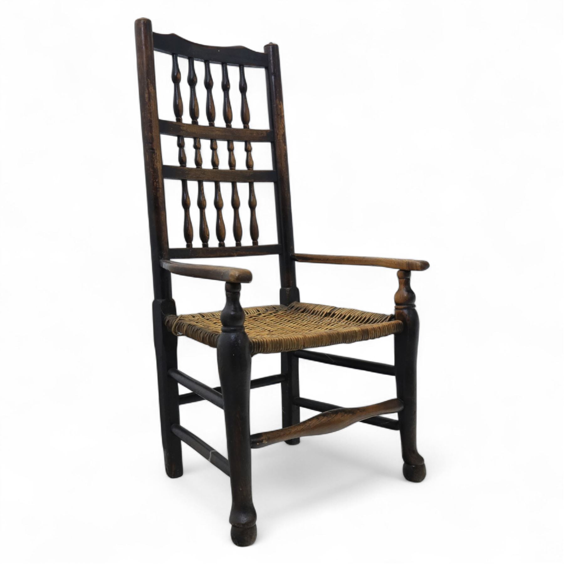 19th century country elm spindle back armchair, shaped cresting rail over two rows of turned spindles, shaped open arms over rush seat, on front turned supports, joined by stretchers 