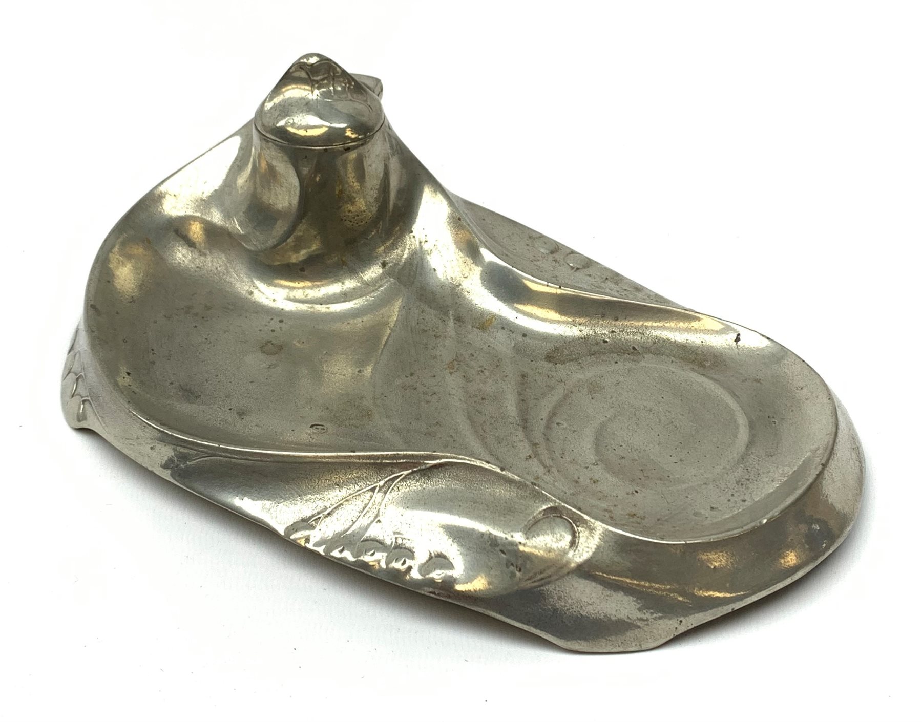 A Kayserzinn Art Nouveau pewter ink stand and pen tray, designed by Hugo Leven, of shaped oval form detailed with stylised tendrils, the hinged inkwell cover opening to reveal an amethyst glass liner, marked beneath Kayserzinn 4438, L21cm.
