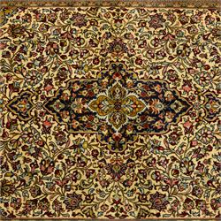 Fine Qom hand-knotted rug, ivory ground, with a dark navy shaped floral medallion and pendants, the field densely worked with fine flowering vines, palmettes and leafy scrolls in red, green, ochre and blue tones, within golden spandrels and a dark navy floral border, flanked by narrow guard stripes, with cotton fringes