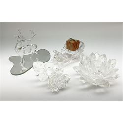 A group of four Swarovski Crystal ornaments, including a rose L9cm, lotus flower, sleigh and reindeer, all in original boxes 