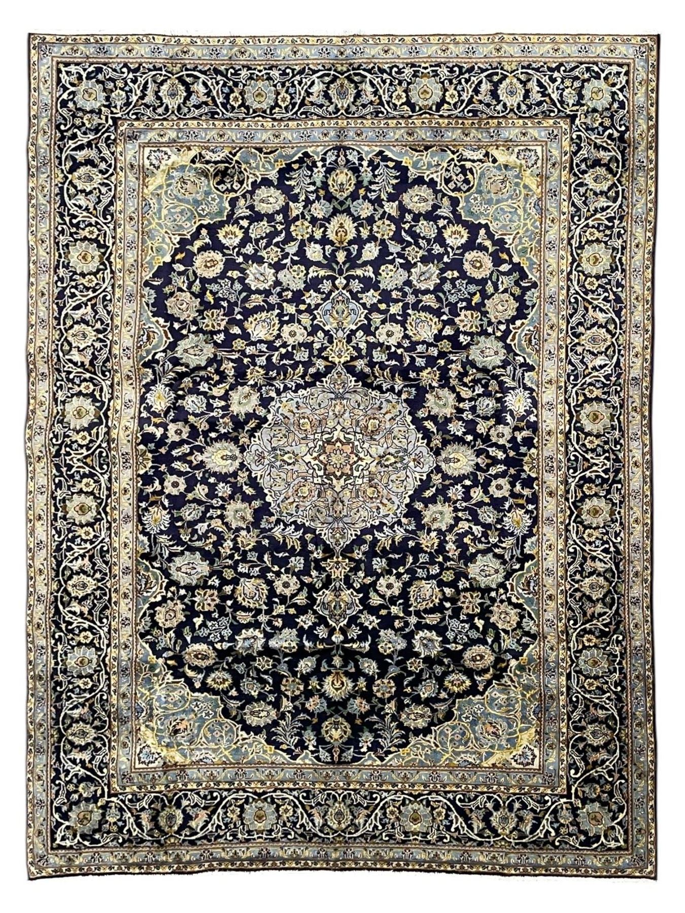 Persian Kashan indigo ground rug, central floral pattern pole medallion, the field decorated with palmettes united by trailing branches, repeating floral pattern border within guard stripes