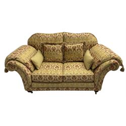 Steed Upholstery Ltd. - 'Lincoln' two-seat sofa upholstered in gold 'Olympia' floral pattern corded and tasselled fabric, together with scatter cushions and arm covers, on turned feet with brass castors