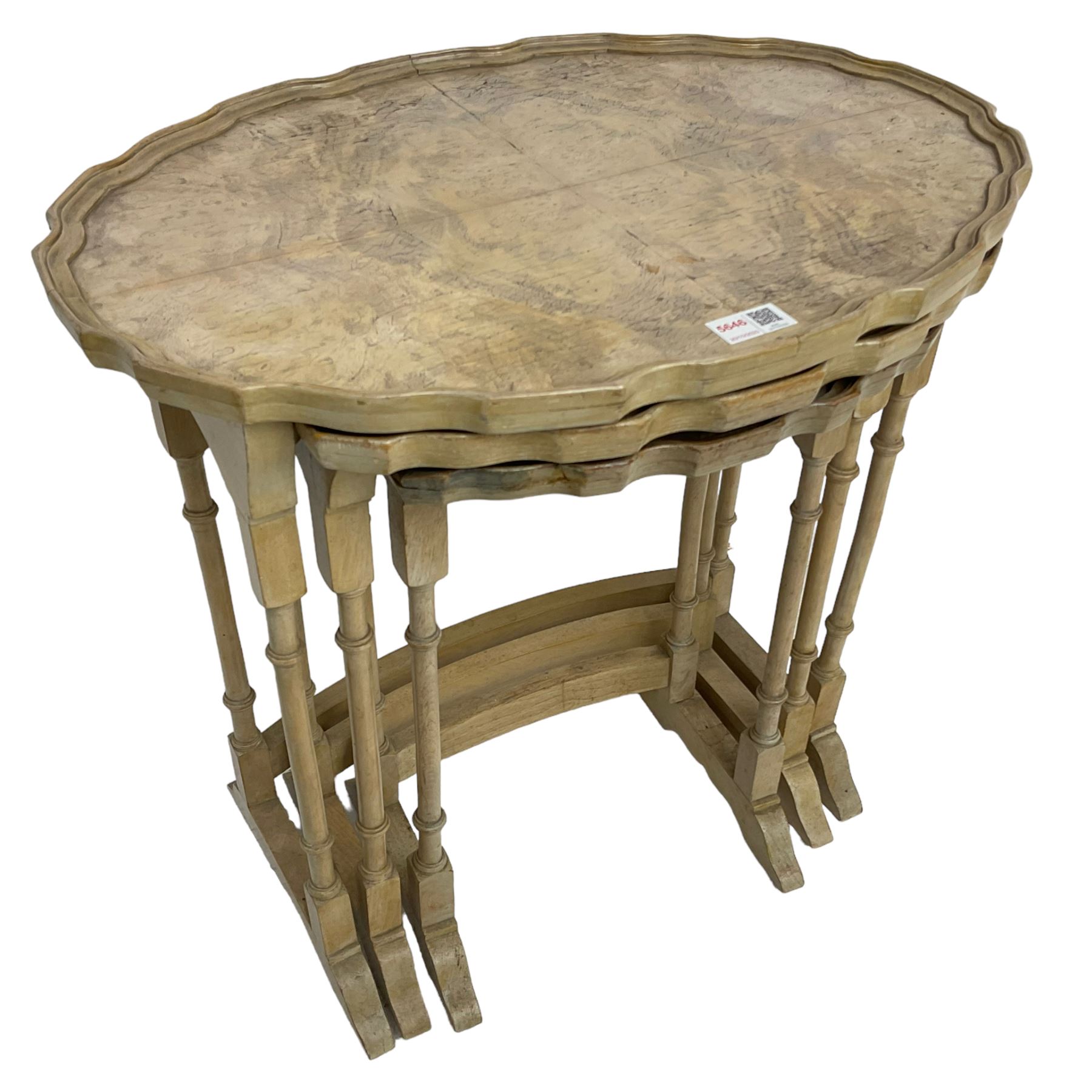 Mid 20th century bleached walnut nest of three tables, oval piecrust tops on turned supports