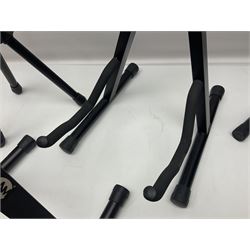 Four folding tubular guitar stands, two by RockJam; and folding tubular saxophone stand (5)