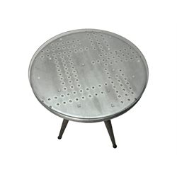 Contemporary industrial design riveted metal table, by repute fashioned from salvaged aeroplane parts, with a circular glass top on a tripod base, accompanied by three adjustable stools upholstered in burgundy