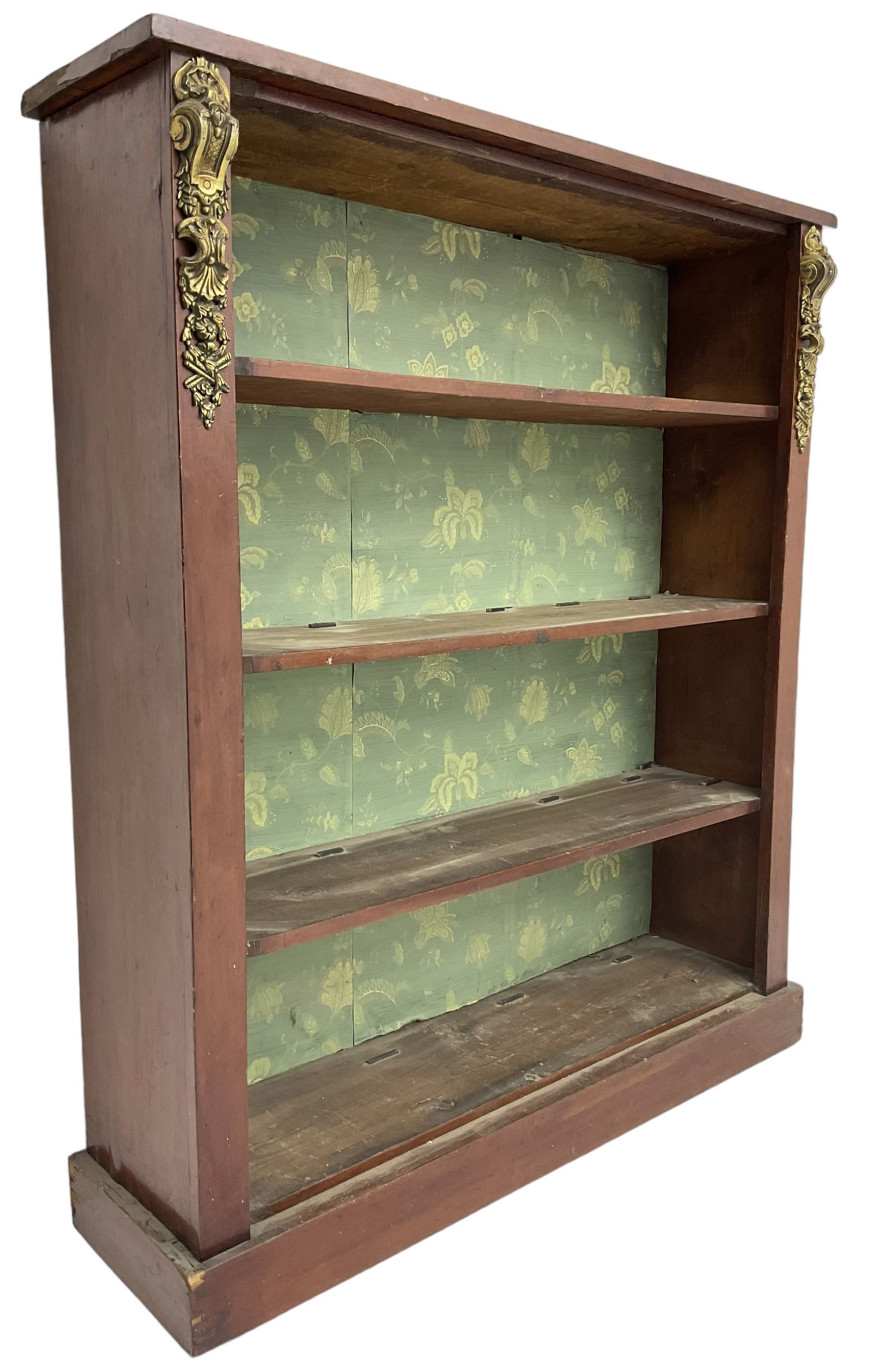 Early 20th century mahogany open bookcase, fitted with three shelves on plinth base, decorated with foliate patterned gilt metal mounts