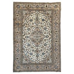 Persian Kashan ivory ground rug, the field decorated with interlacing branches and palmettes, central floral design pole medallion, the scrolling border decorated with stylised plant motifs, within repeating flower head guard stripes