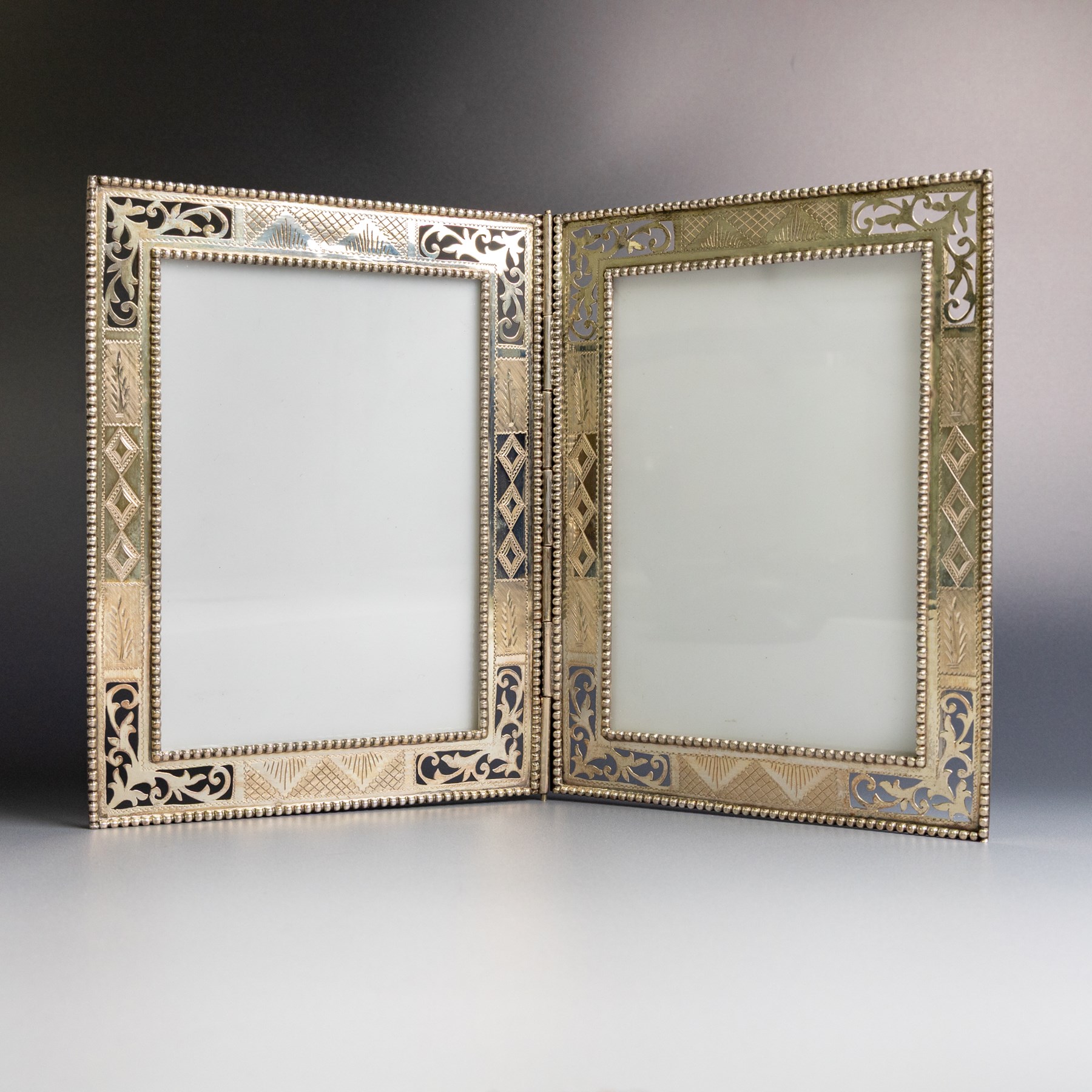 Indian silver double folding photograph frame, of rectangular form with beaded border and pierced decoration, H19.5cm