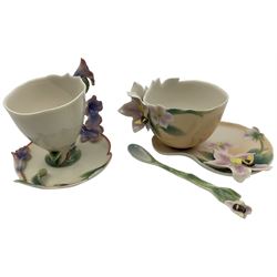 Two Franz teacups and saucers, decorated with flowers, one with matching teaspoon