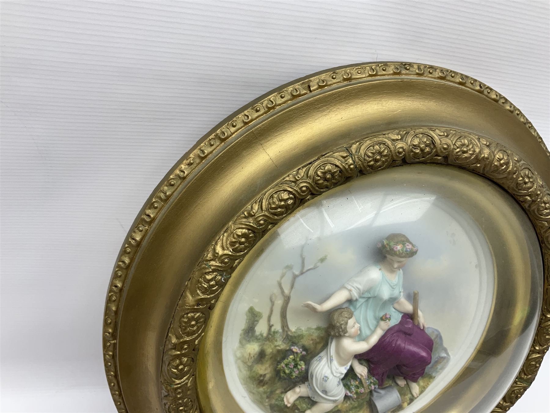 Set of four early 20th century Continental bisque plaques, each of circular form, modelled in high relief as the Four Seasons personified, within gilded circular frames under convex glass, overall D44.5cm
