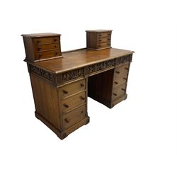 Late 19th century heavily carved oak twin pedestal desk, rectangular top with two raised trinket or correspondence structures each with three drawers, rectangular top over three frieze drawers carved with acorn and oak leaf decoration, each pedestal with three drawers with acorn husk shaped handles