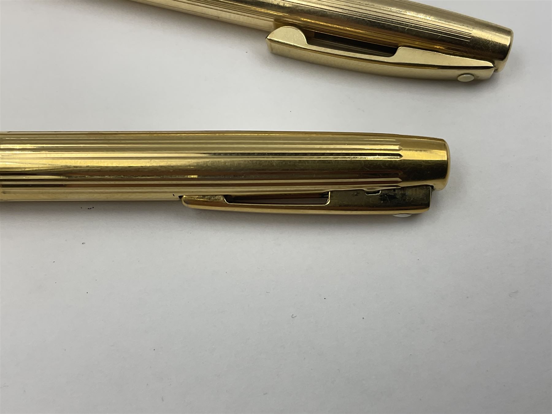 Sheaffer Triumph Imperial fountain pen, the gold plated barrel with fluted stripe design and gold nib stamped 14K 585, together with a Sheaffer Targa slimline fountain pen with gold plated barrel similarly decorated with gold nib stamped 14K 585, ballpoint pen and propelling pencil, each with a fluted gold plated barrel, largest L13.5cm (4)
