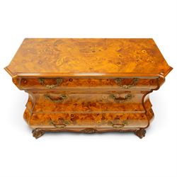 Colombo Mobili - Italian walnut and floral marquetry bombé commode chest, rectangular top with canted eared corners inlaid with urn motif and trailing scrolling foliage, fitted with three long graduating drawers with gilt metal handles, profusely inlaid with scrolling acanthus leaves interspersed with urns and cartouches, on large carved ball-and-claw feet