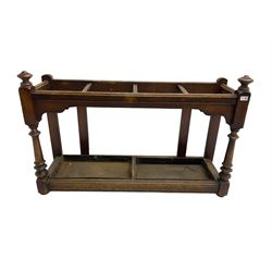 Edwardian oak hallway stick and umbrella stand, four divisions on turned supports, with metal tray liners and various sticks