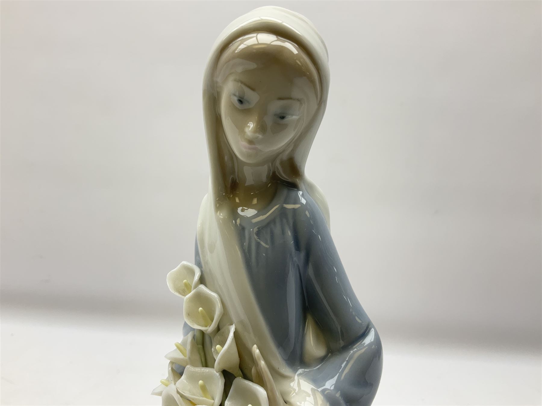 Four Lladro figures, comprising Afternoon Promenade no 7636, Nostalgia no 5071, both with original boxes, Girl with Lilies no 4972 and Madonna no 4534, largest example H27cm
