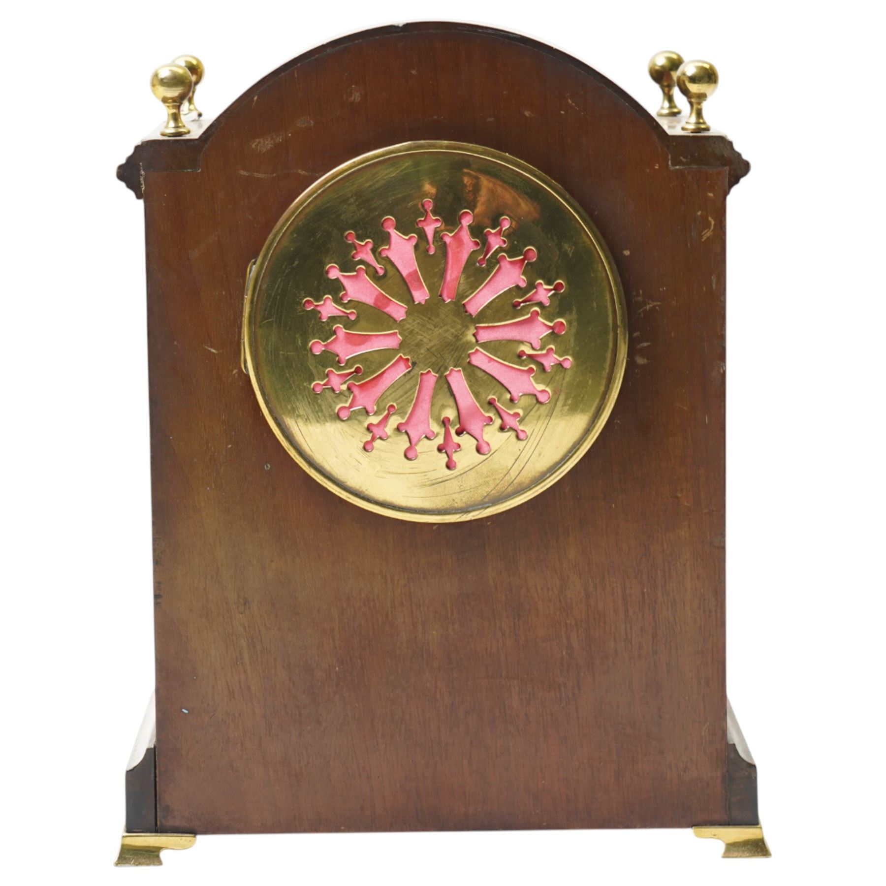 Edwardian-French mahogany cased mantle clock c1910 in a break-arch case with brass finials and recessed brass columns, with inlaid satinwood stringing and conche inlay to the front, raised on a short plinth with bracket feet, twin train movement with rack striking, sounding the hours and half-hours on a coiled gong.
With pendulum and key.
