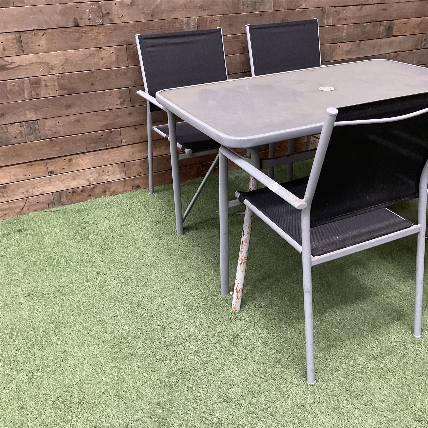 Rectangular metal framed garden table with glass top and four stackable chairs - THIS LOT IS TO BE COLLECTED BY APPOINTMENT FROM DUGGLEBY STORAGE, GREAT HILL, EASTFIELD, SCARBOROUGH, YO11 3TX