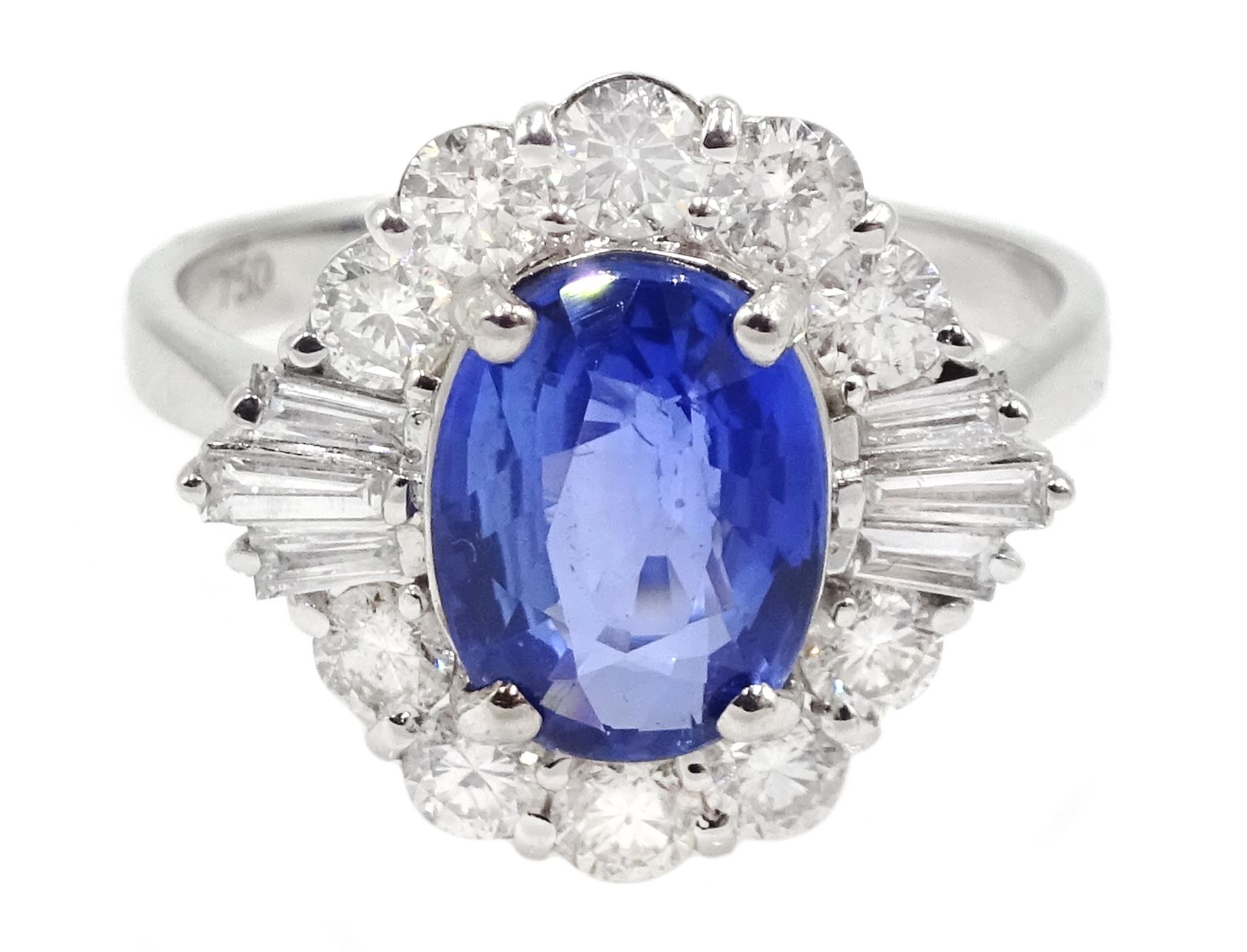 18ct white gold sapphire and diamond cluster ring, the central oval sapphire of approx 2.10 carat, with tapered baguette diamonds and round brilliant cut diamond surround, stamped 750