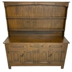 Medium oak dresser, raised two-tier plate rack over three drawers and two double cupboards, enclosed by panelled doors