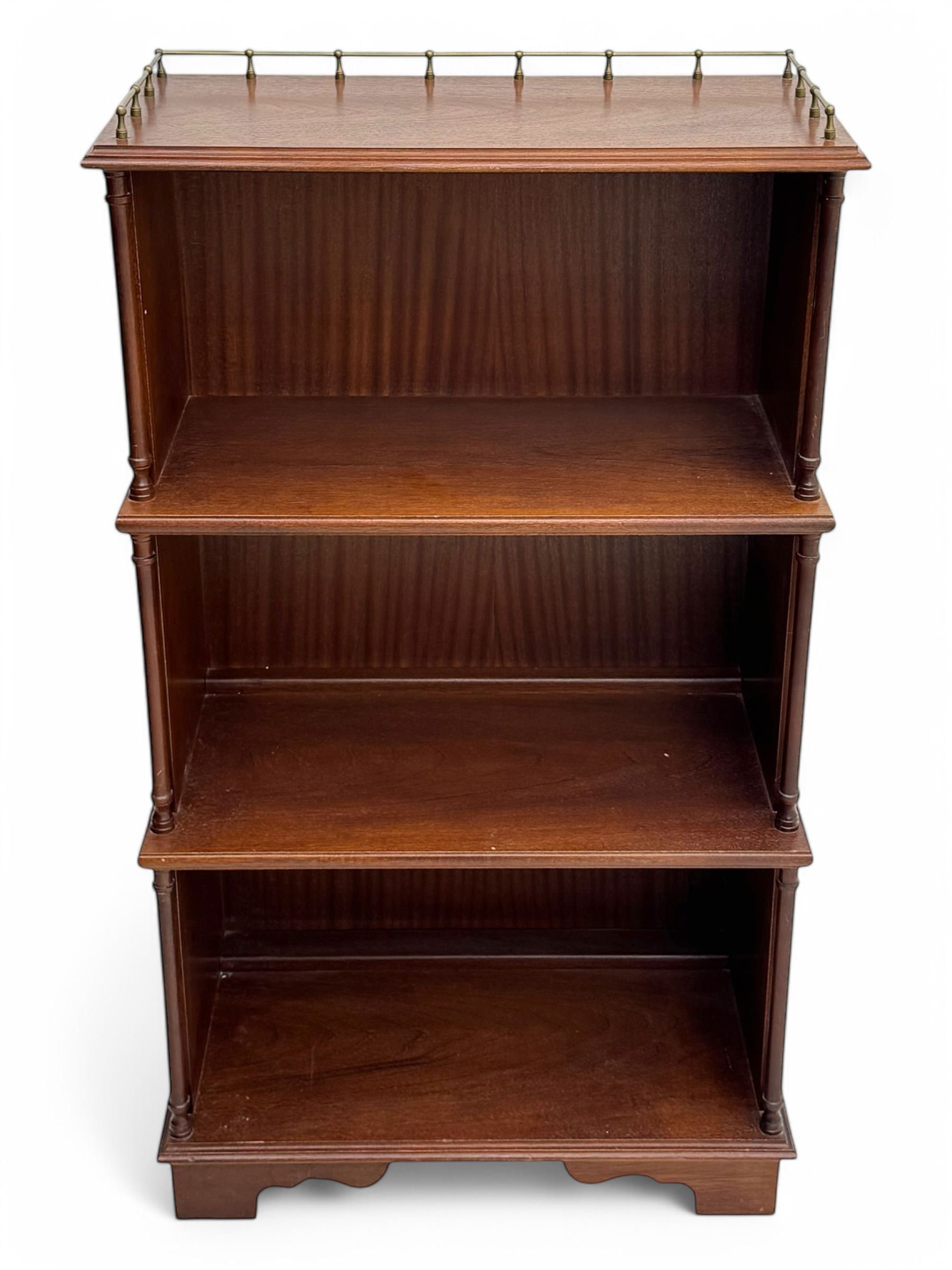 Mid-20th century mahogany open bookshelf, the rectangular top with a brass balustrade gallery, over three shelves each supported by turned column uprights, on shaped apron base