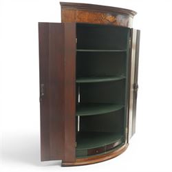 Georgian inlaid walnut cylindrical corner cupboard, projecting cornice over a banded frieze with inlaid shell motif, enclosing three shelves with two spice drawers fitted to base