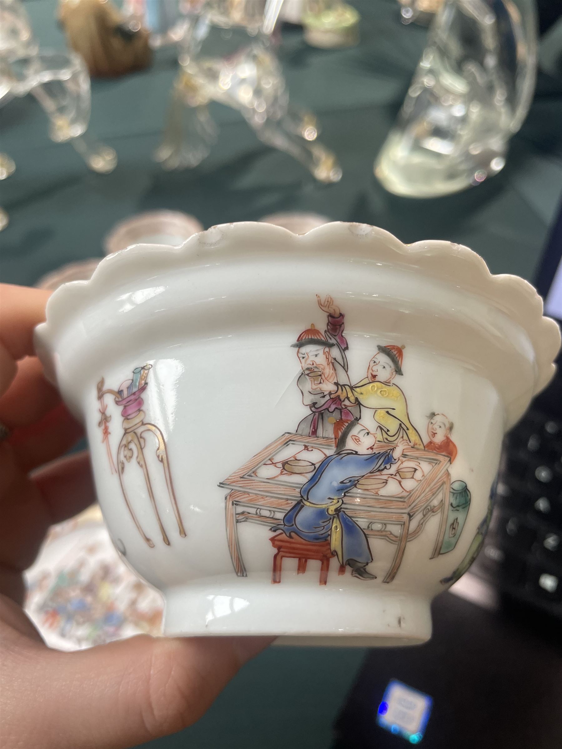 Set of Chinese 20th century tea wares, comprising three bowls of graduating sizes, teacup, spoon rest and small plate, decorated with scenes of figures around a table, each with scalloped rim, largest bowl D12cm