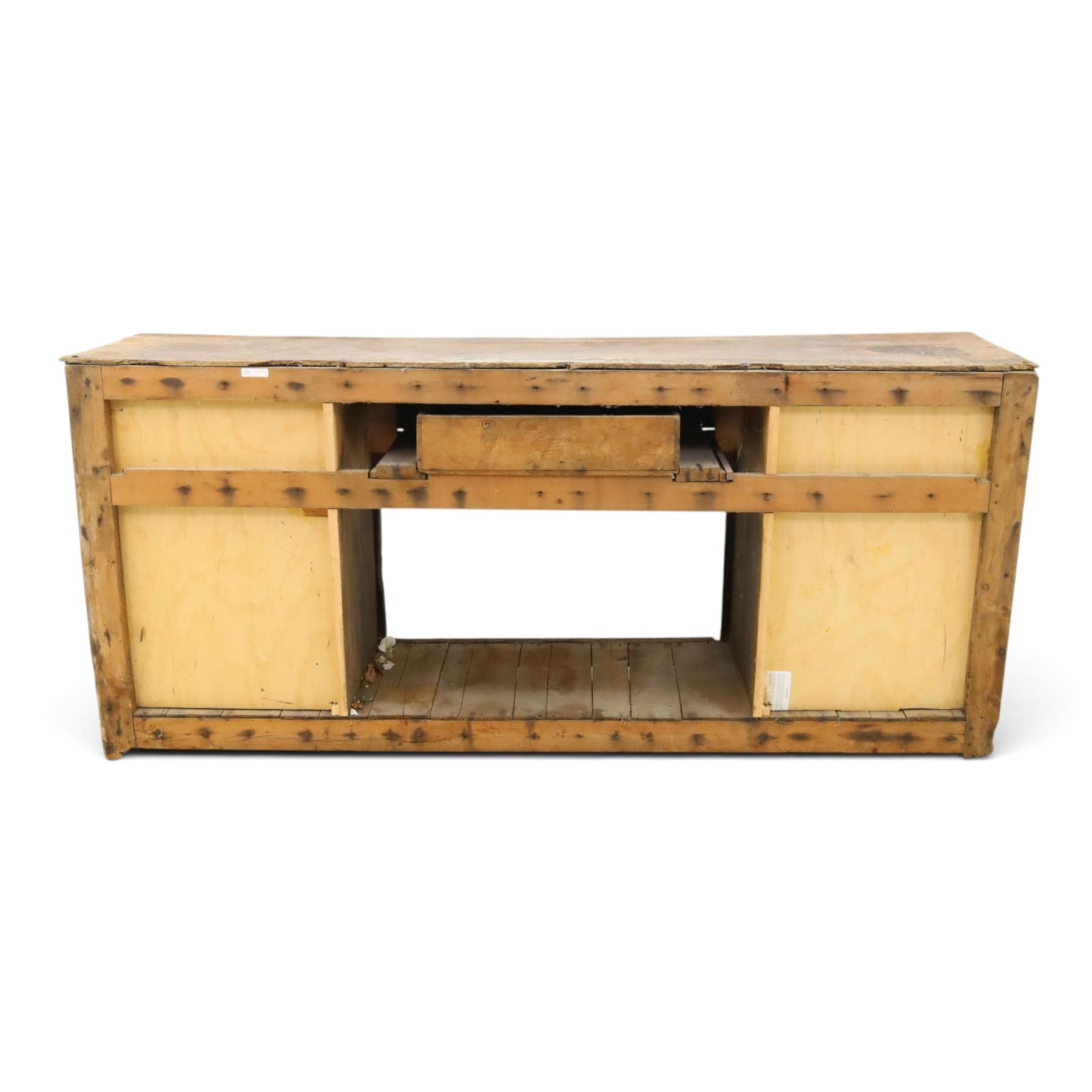18th century rustic oak dresser base, with fielded panels and iron cup handles with embossed greek key and foliate detail, three short drawers above and open recess flanked by two cupboard doors, raised on stile supports