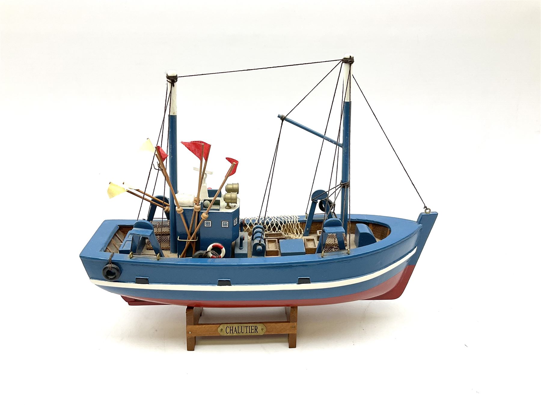 Wooden model of RMS Titanic, on a fixed black stand bearing plaque inscribed 'Titanic 1912', L54cm, H22cm, together with model of a sloop, gaff rigged on stand bearing plaque inscribed 'Sloop' L32cm, H42cm; and model of a fishing trawler on a stand bearing plaque inscribed 'Chalutier' L35cm, H28cm (3)