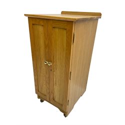 Bespoke light oak floor standing medal cabinet with two panelled doors enclosing fourteen graduated drawers with brass knob handles, on castors W45cm H98cm D50cm