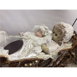 Two decorative wicker dolls prams, one with lace parasol,  and eleven dolls, including Leonardo Collection porcelain dolls, tallest pram including parasol H105cm
