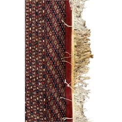Large Persian Bokhara red ground carpet, the field decorated with eight rows of Gul motifs, wide multi-band borders decorated with repeating geometric motifs