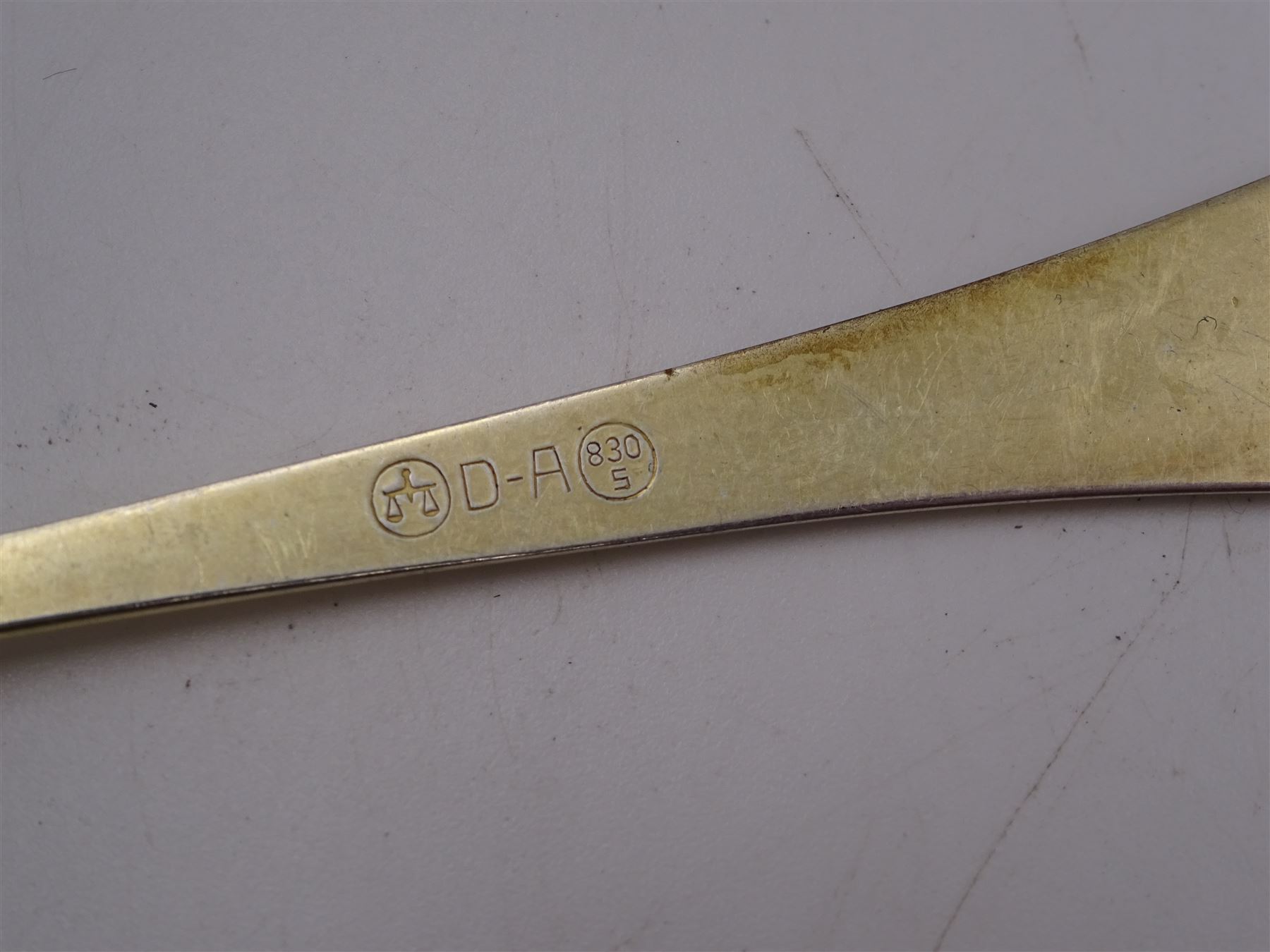 Collection of Norwegian silver flatware, including a set of six silver-gilt demitasse spoons, by David Andersen, stamped D-A 830s and a serving spoon, the pierced terminal with two doves, engraved with initial K and dated 10.09.32 verso, stamped 830s, etc