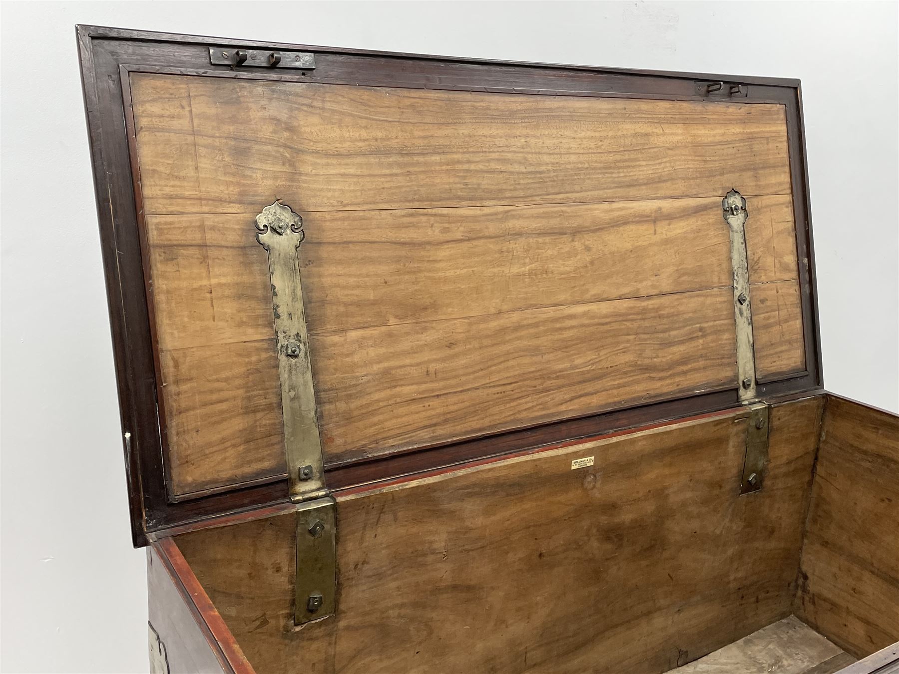 19th century camphor wood and mahogany silver chest, the hinged banded top with circular brass mounts which secure the interior strap hinges, fretwork metal strapping to the corners, on stand with plain frieze and acanthus carved cabriole ball and claw feet