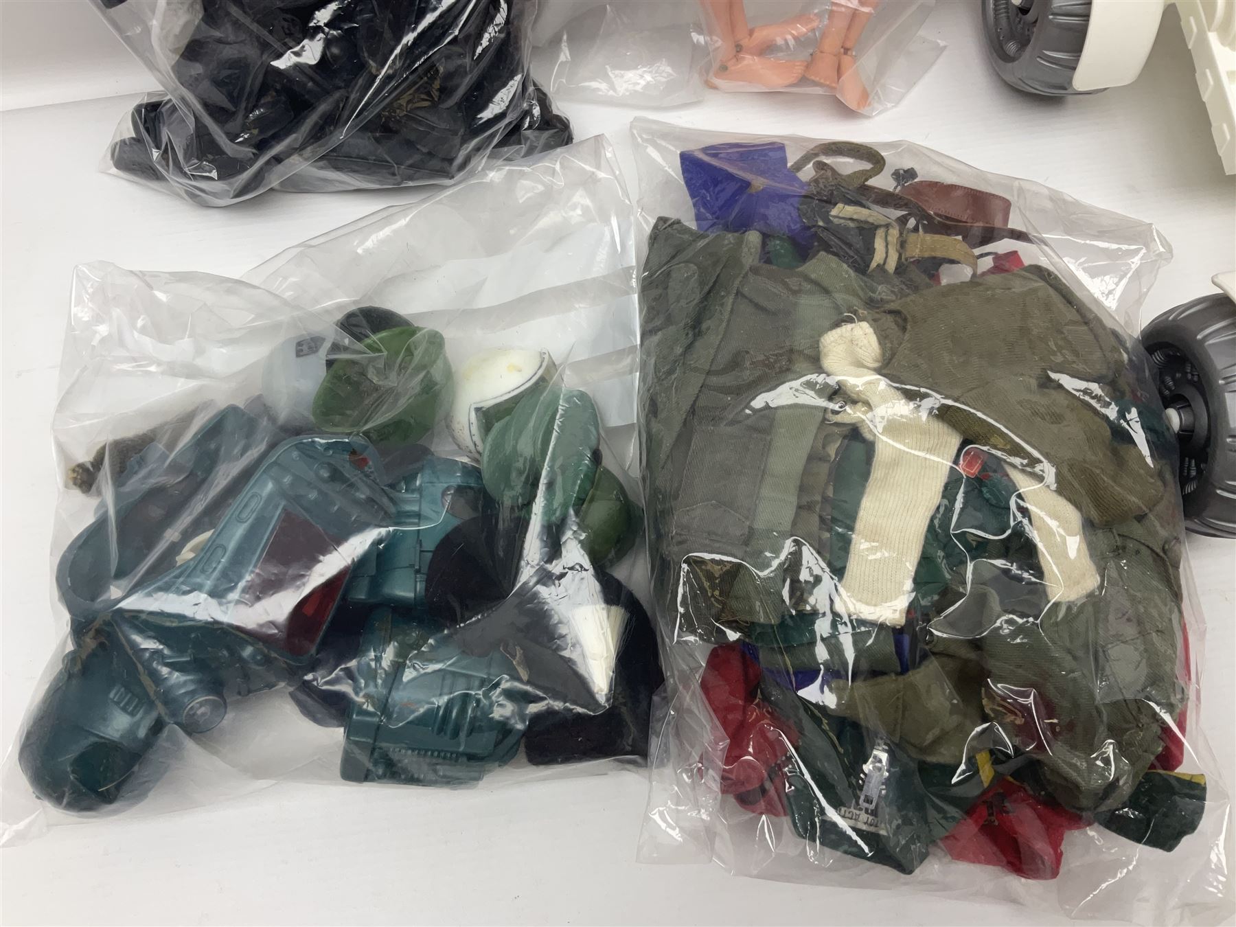 Action Man - large collection of 1960s and later figures and accessories including Spaceman with ATLRV vehicle; two figures marked 'Made in England by Palitoy under licence from Hasbro 1964'; twenty-five assorted weapons; radio backpacks; kit bags; twenty-one pairs of boots; football boots and snow shoes; metal diver's boots and three pairs of flippers; two pairs of jackboots; roller skates; various tunics, trousers, flying suits, jumpers, belts etc; twenty helmets, berets, busby, kepis, submariner etc; and quantity of other accessories